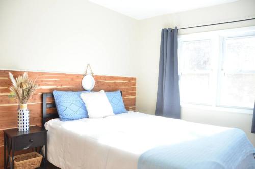 sypialnia z łóżkiem z niebieskimi poduszkami i oknem w obiekcie 3 bedroom country home pet friendly w mieście Monroe