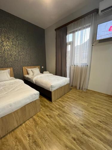 Habitación de hotel con 2 camas y TV de pantalla plana. en NAREMA FAMILY HOTEL MEGHRI, en Meghri