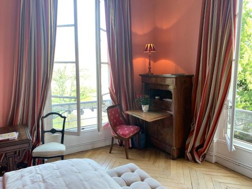 a bedroom with a bed and a desk and a window at Domaine de Macque, BETZ, 25 mns Roissy CDG in Betz