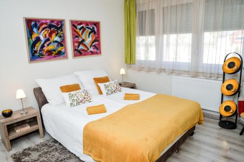 ハイドゥソボスローにあるFlamingó Apartmanのベッドルーム1室(大型ベッド1台、黄色い毛布付)