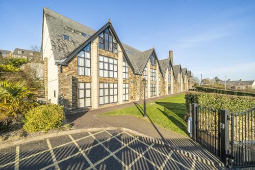 an exterior view of a house with a fence at Pochin House Collections in St Austell