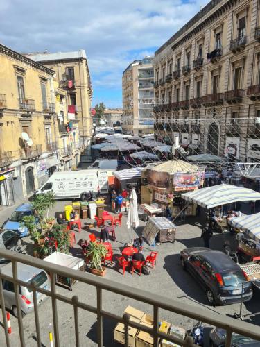 an outdoor market with tables and chairs in a city at Toscano Palace Luxury Rooms Catania in Catania