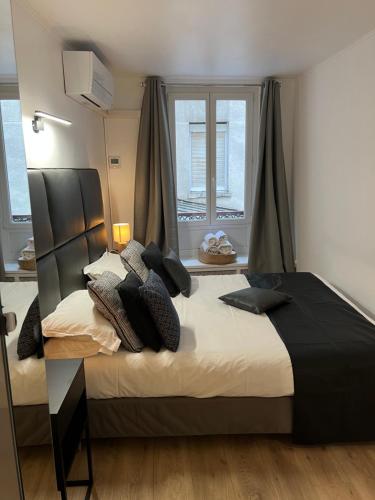 une chambre avec un grand lit avec des oreillers dessus dans l'établissement NOTRE DAME - STYLISH APARTMENT, à Paris