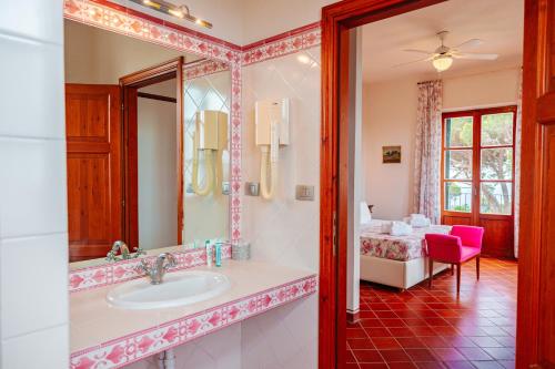 a bathroom with a sink and a mirror and a bed at Tenuta Delle Ripalte in Capoliveri