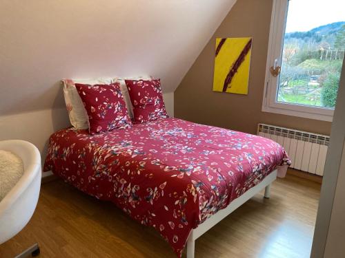 Un dormitorio con una cama con sábanas rojas y una ventana en Chez Dina en Lutzelhouse