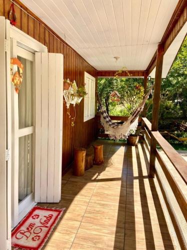 a porch of a house with a hammock on it at Chalé Recanto dos Pássaros in Gramado