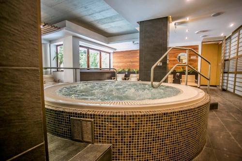 una gran bañera de hidromasaje en una habitación con en Bassiana Hotel es Etterem, en Sárvár