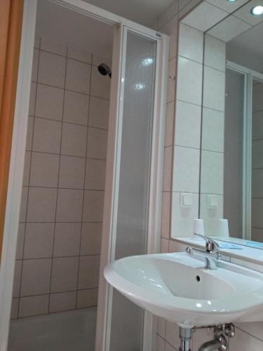 uma casa de banho com um lavatório branco e um chuveiro em Pension Christ em Waltershausen