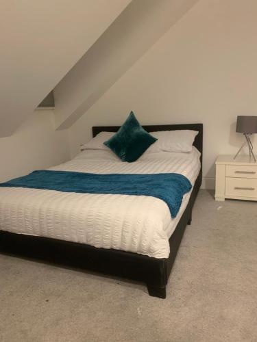 a bedroom with a bed with a green pillow on it at HU1 Triplex City Centre Gem sleeps 6 H7 in Hull