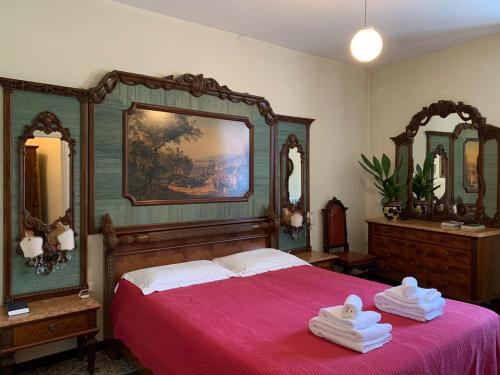 a bedroom with a bed with a red bedspread and mirrors at Albergo Dell'Angelo in Pieve di Teco