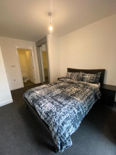 a bedroom with a bed with a comforter on it at Luxury Modern 2 bed room apartment. in Belvedere