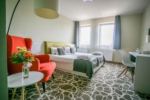 Habitación de hotel con cama, mesa y sillas en Bassiana Hotel es Etterem, en Sárvár