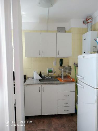 a kitchen with white cabinets and a white refrigerator at Departamento Guemes in Buenos Aires