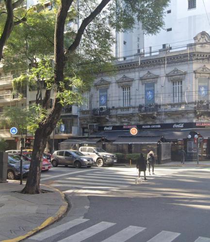 uma pessoa a atravessar uma rua em frente a um edifício em Departamento Guemes em Buenos Aires