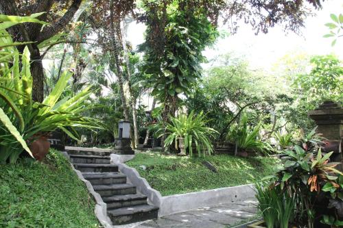 a garden with stairs and trees and plants at Bali Agung Village - CHSE Certified in Seminyak