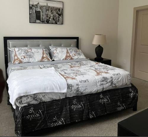 a bedroom with a bed with a black and white comforter at Home felt apartment- Med Center/NRG in Houston