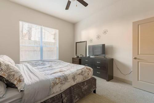 1 dormitorio con 1 cama, TV y ventana en Home felt apartment- Med Center/NRG en Houston