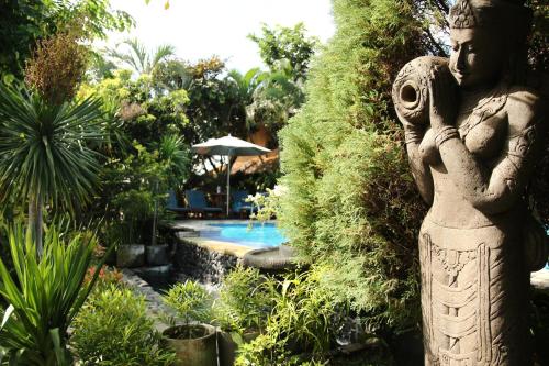 a statue of a woman standing next to a swimming pool at Bali Agung Village - CHSE Certified in Seminyak