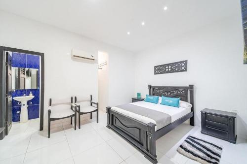 1 dormitorio con cama, silla y lavamanos en Hotel Mar di Plata, en Barranquilla