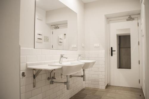 a white bathroom with two sinks and a mirror at room00 Salvador Hostel in Seville