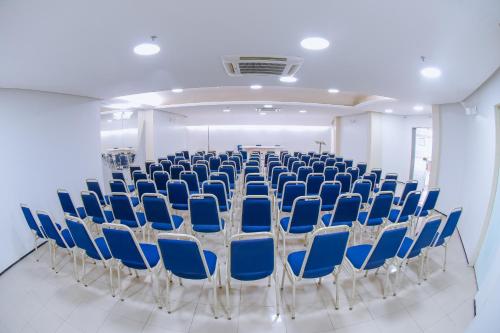 a room with rows of blue chairs in a room at Hotel Praia Ponta d'Areia in São Luís