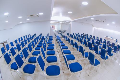 a row of chairs with blue seats in a room at Hotel Praia Ponta d'Areia in São Luís