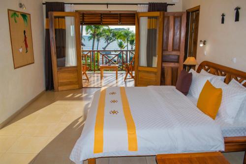 a bedroom with a bed with a view of the ocean at Vanila Hotel & Spa in Ambaro