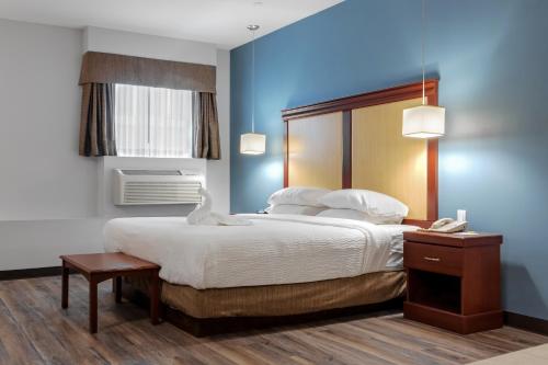 een slaapkamer met een groot bed en een telefoon bij Premier Inn & Suites - Downtown Hamilton in Hamilton