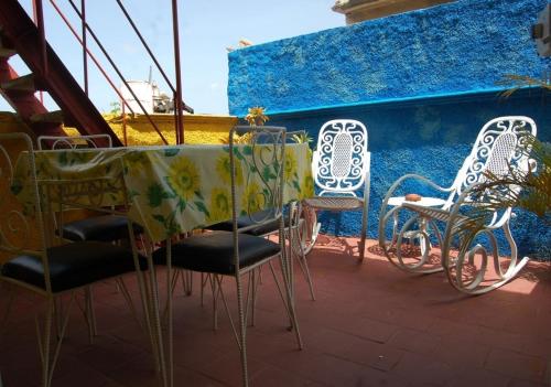 a table and chairs on a patio with a blue wall at Hostal Bitton Appartement 3 in Trinidad
