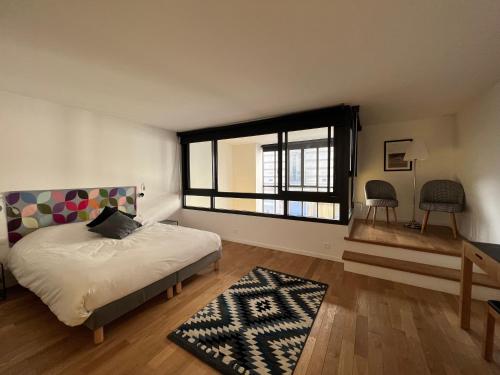 sypialnia z łóżkiem i dużym oknem w obiekcie Hôtel Villa Blomet w Paryżu