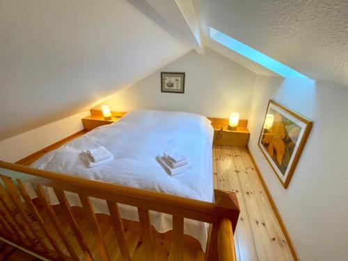 a attic bedroom with a bed with two towels on it at Eichenhof III in Grothusenkoog