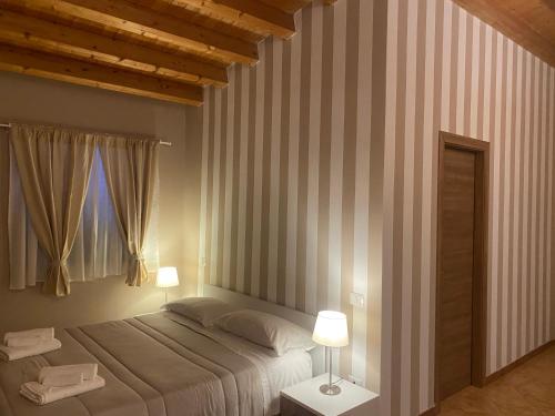 a bedroom with a large bed and a window at La Valle degli Ulivi in Acquedolci