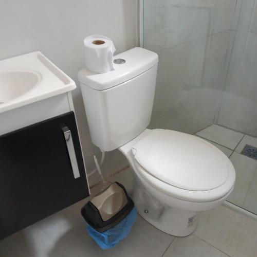 uma casa de banho branca com um WC e um lavatório em Edícula no centro de VR em Volta Redonda