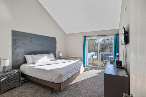 1 dormitorio con cama, TV y balcón en Osage Beach Wonder, en Osage Beach