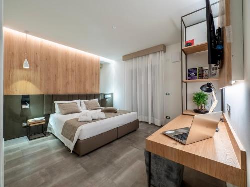 1 dormitorio con 1 cama y escritorio con ordenador portátil en Venice Green Residence, en Mestre