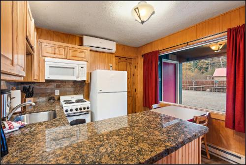 a kitchen with a white refrigerator and a stove at Brundage Bungalows in McCall