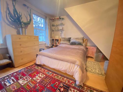 a bedroom with a bed and a rug at The blue door in London