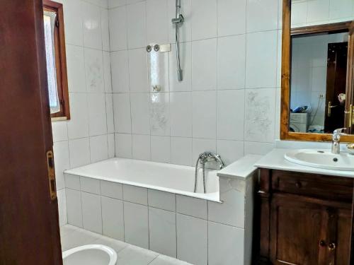 a white bathroom with a tub and a sink at Appartamento Dimora dei marchi in Cosenza