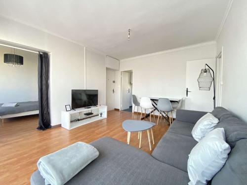 uma sala de estar com um sofá e uma sala de jantar em L'ISKANDER - Apaisant 3 chambres 