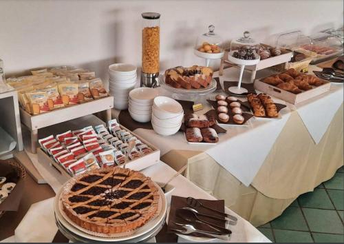 una tavola piena di diversi tipi di dolci e dolci di Hotel Baia Verde Gallipoli a Gallipoli