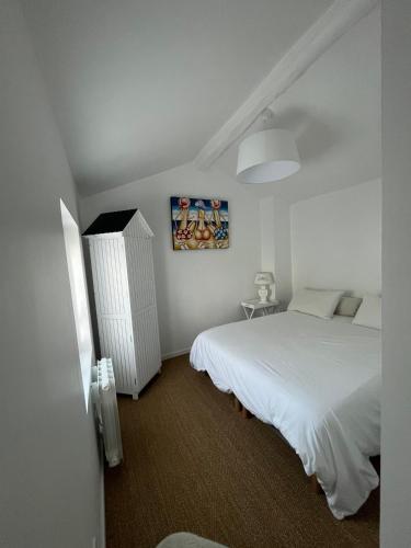 une chambre avec un lit et un tableau au mur dans l'établissement Maison centre ville Touques, à Touques