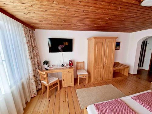 a bedroom with a desk and a bed and a table at Ferienhof am Landsberg in Obergrünburg