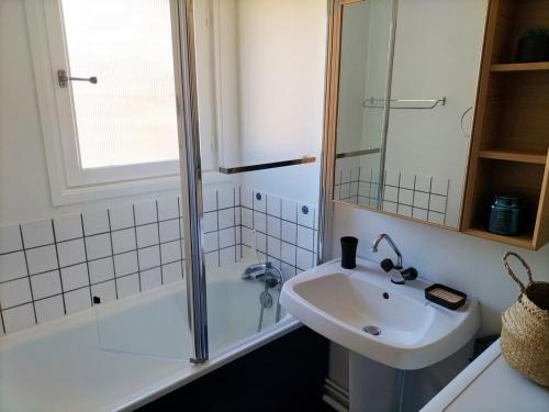 y baño blanco con lavabo y ducha. en VUE MER Vacances en famille a cinq a Arzon, en Arzon