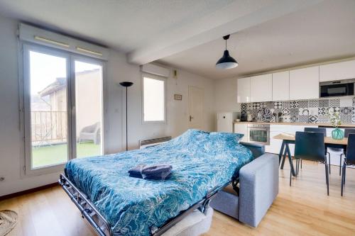 - une chambre avec un lit doté d'une couverture bleue dans l'établissement Apt de 30 m2 - 5 min de Bordeaux - terrasse - parking, à Cenon