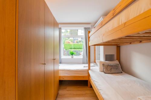 a small bedroom with two bunk beds and a window at The Peak by Afan Valley Escapes in Cymmer