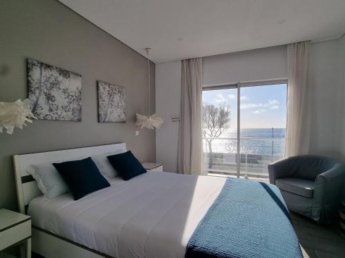 um quarto com uma cama e uma grande janela em Bay House - Sealife Apartment em Ponta Delgada