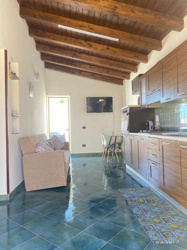 a living room with a couch and a kitchen at Villa Ale in Lampedusa