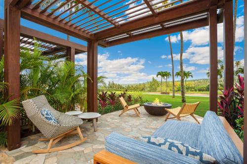 un patio al aire libre con pérgola y sillas en The Ritz-Carlton Maui, Kapalua en Lahaina