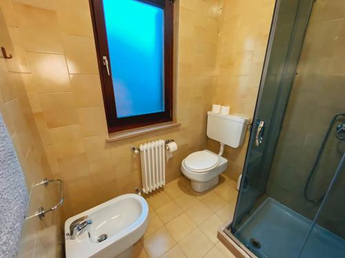 a bathroom with a toilet and a sink and a shower at Mini appartamento panoramico in Sùtrio