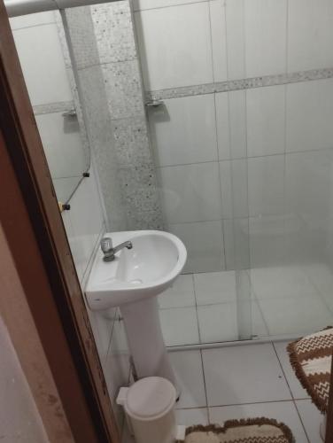 a white bathroom with a sink and a toilet at Cantinho Nativus in Maragogi